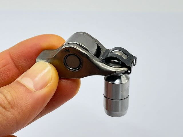 Rocker arm held on a Denstoj pivot by a rocker retainer clip